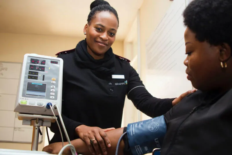 Black nurse taking blood pressure from patient