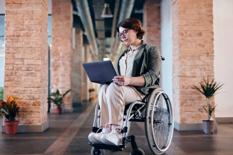 girl on a wheelchair using her laptop